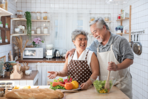 Senior couple aging in place and having fun in kitchen with healthy food.