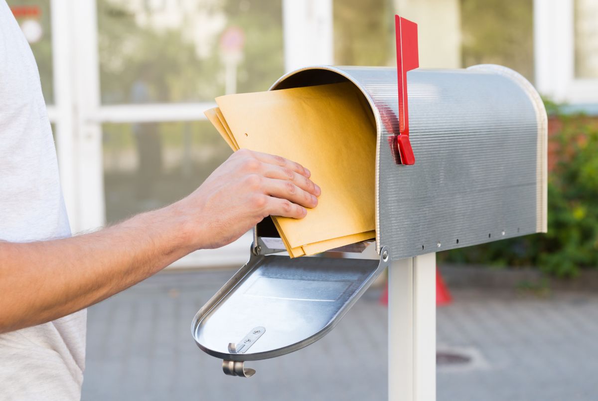 person grabbing mail form mailbox regarding medicare's annual notice of change that is sent